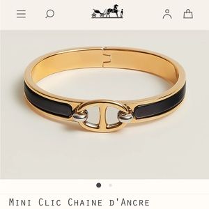 Hermes bracelet with black and gold tone.